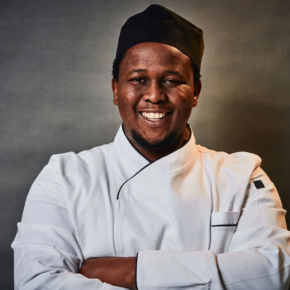 Smiling chef standing comfortably in the kitchen