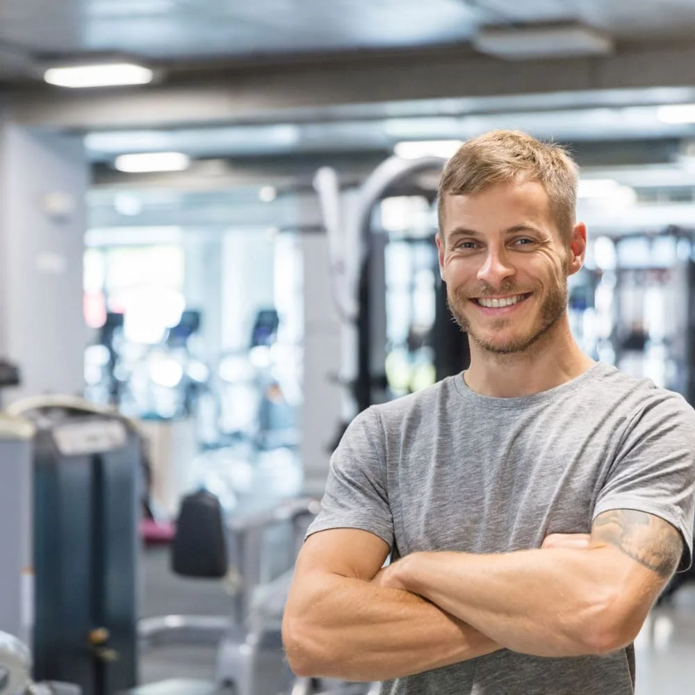 Man with arms crossed after a workout at the gym